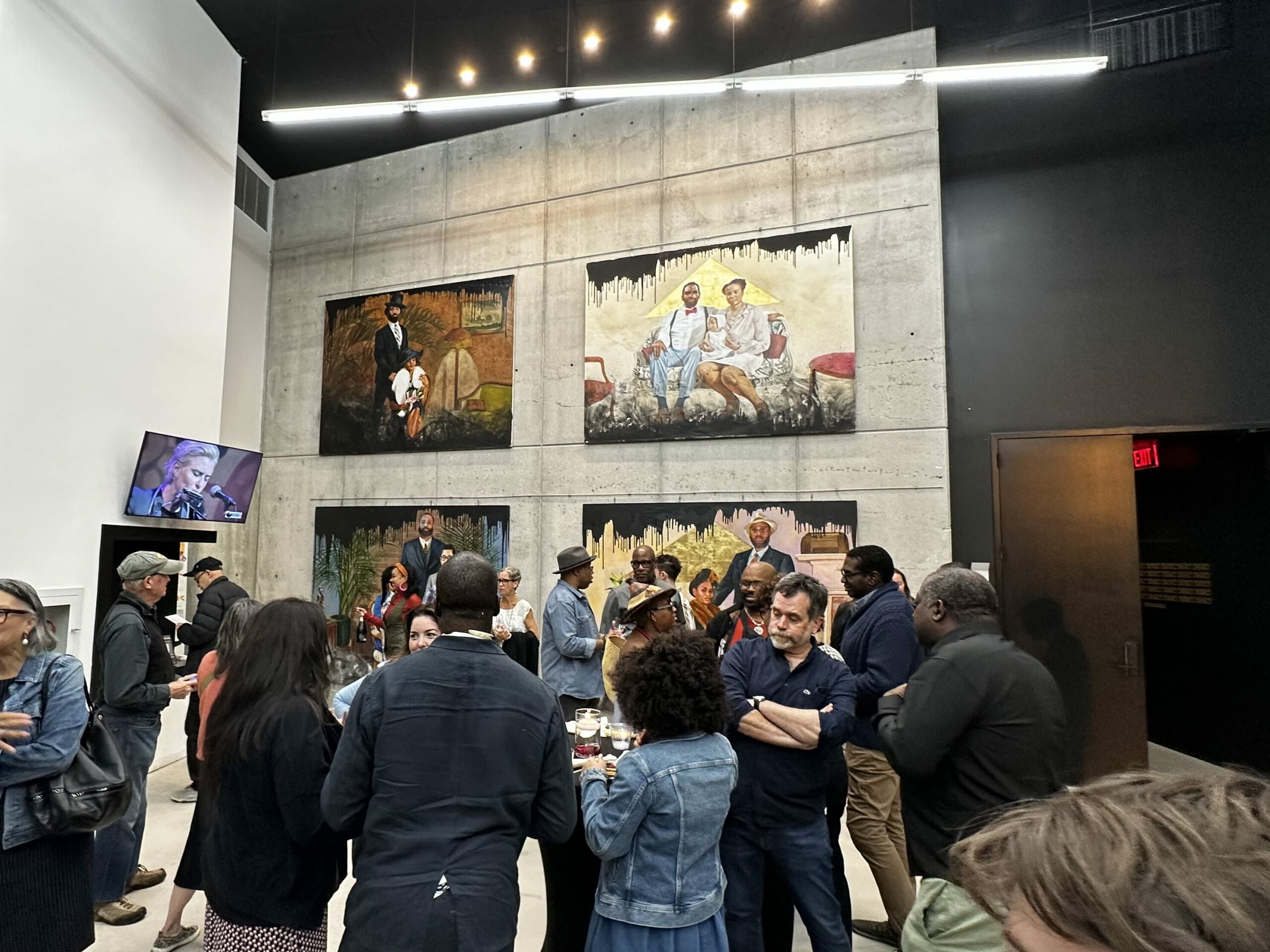 A crowd of people stand and walk around Nimbus Arts Center's Firmament Gallery at a Bridge Art Gallery reception. 